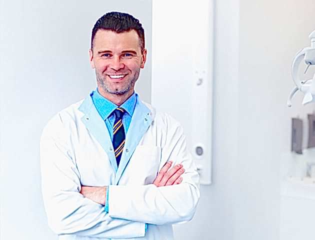 Man odontologist standing in dental clinic and waiting for next patient.
