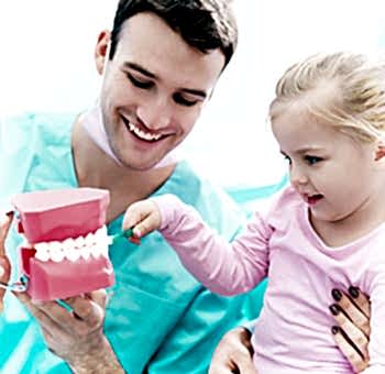 Dentist showing to a patient how to brush teeth correctly.