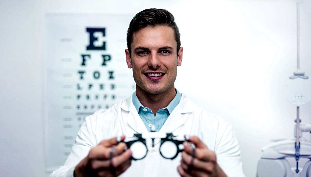 Optician handing messbrille glasses during eye test.